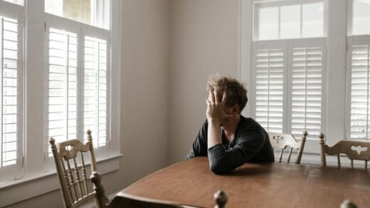 photo of man leaning on wooden table