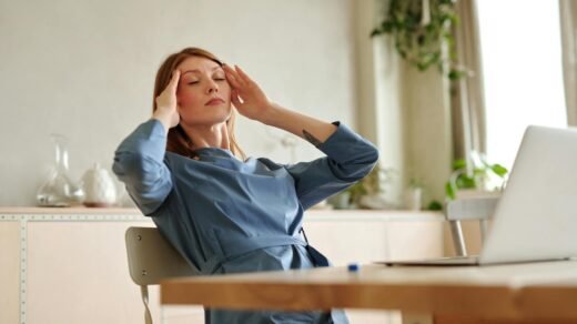 woman in blue dress touching her head