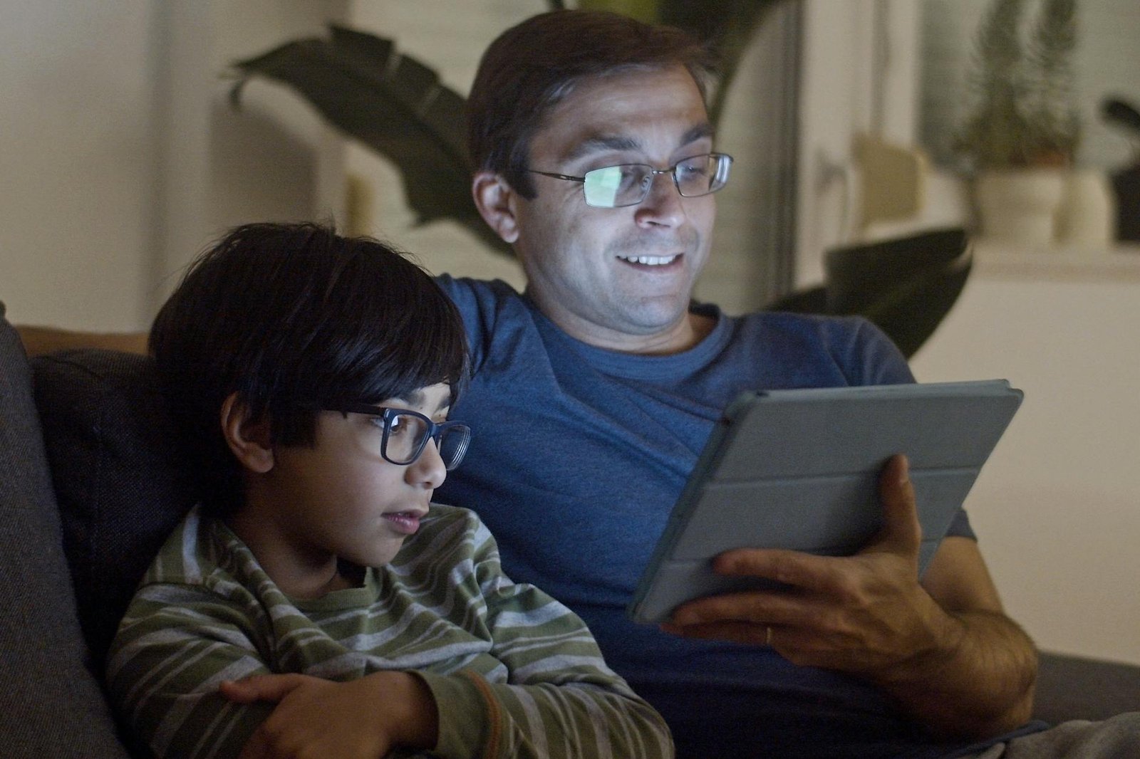 father and son watching video