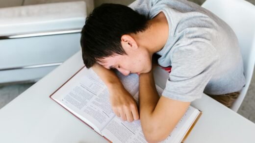 boy sleeping on an open book on a white table