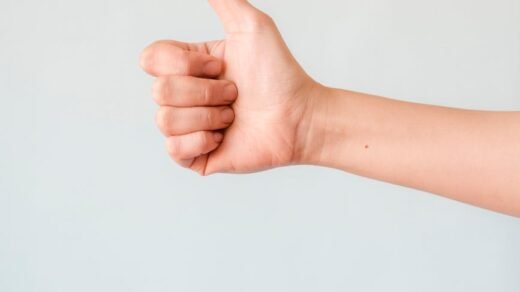 person s right hand doing thumbs up